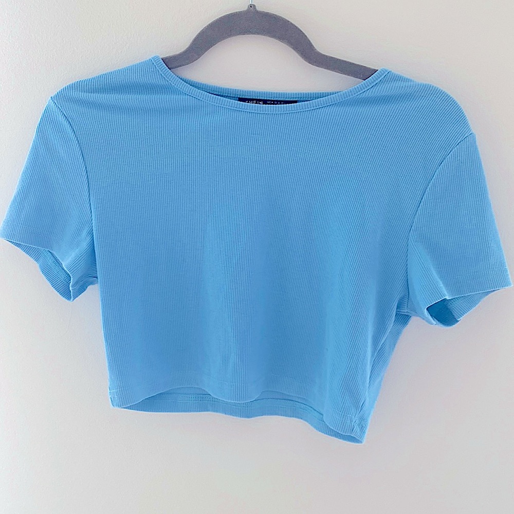 Light blue cropped shirt.
